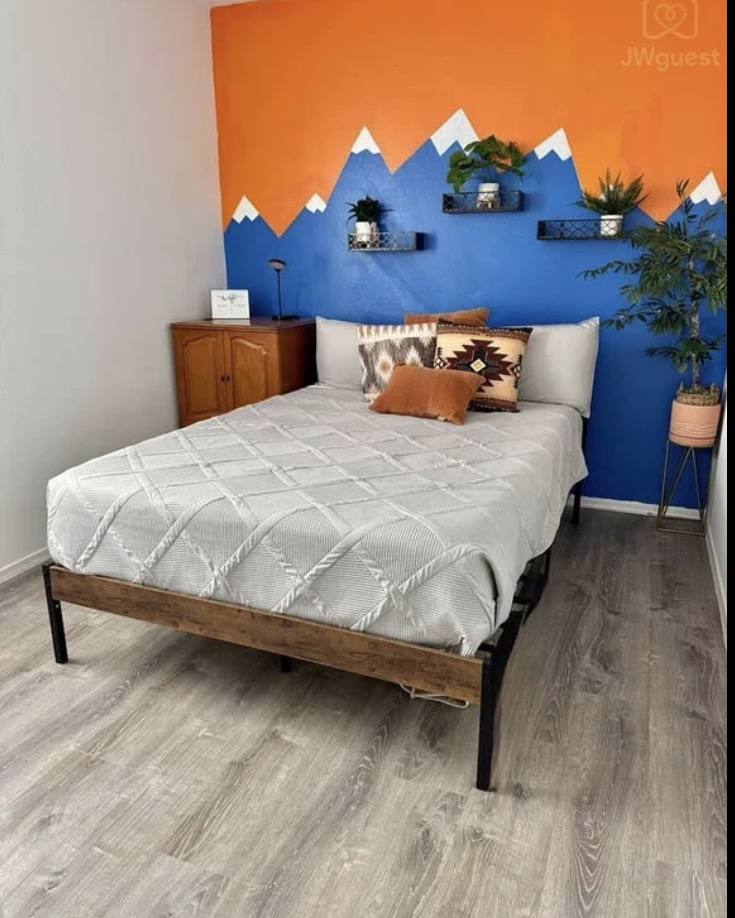 Guest bedroom with hand-painted desert mountain mural and queen bed