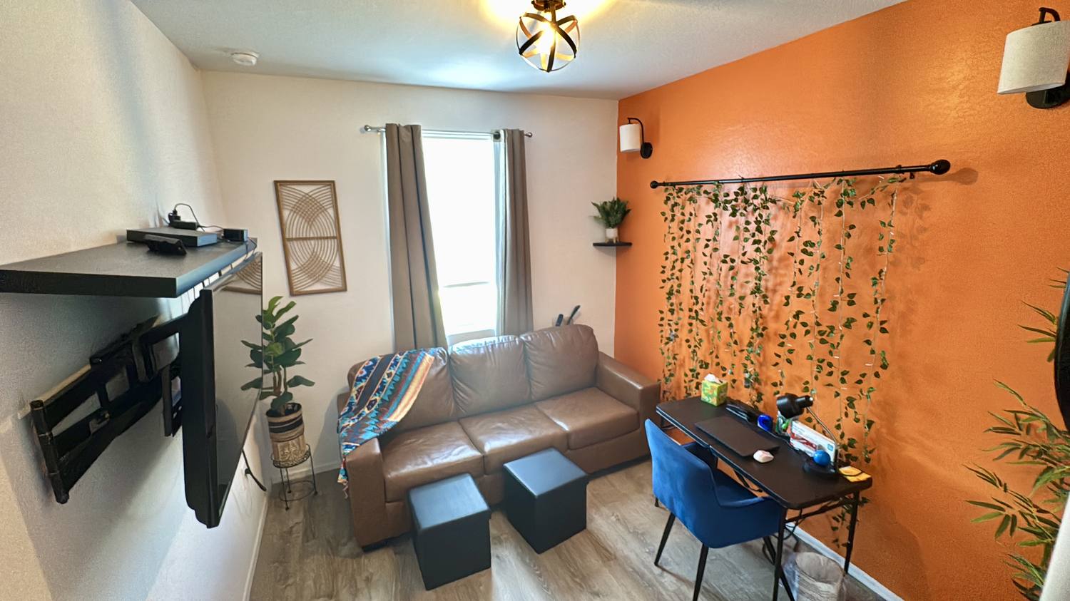The sitting room by day — sofa, desk and terracotta accent wall
